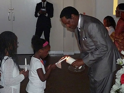 Amb. Nkrurunziza and a young mourner light the candle of hope. Courtesy photo.