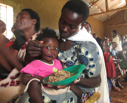 Beatrice Mukantwari feeds her daughter Chantal Igiraneza during a hearth session recently. The New Times/ Clu00e9ment Uwiringiyimana.