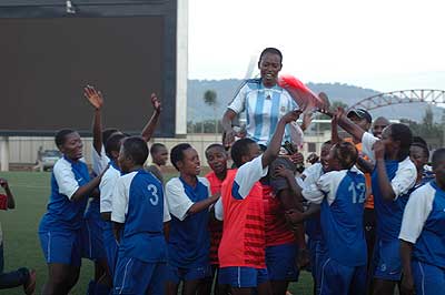 The AS Kigali coach is carried shoulder high  by her players after winning the women soccer league title. Sports Magazine / T. Kisambira.