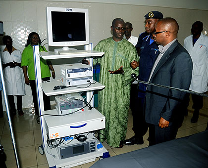 Fall (L) explains to officials how the laporoscopy machine works during the hand-over ceremony yesterday. The New Times/ John Mbanda.omen.