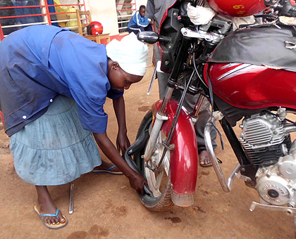 Aloysie Benimana (Mama Gatoya) repairing a motorbike. The Sunday Times / Courtesy.