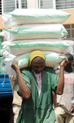 A labourer offloads maize flour, one of the fortified foods. The New Times / John Mbanda