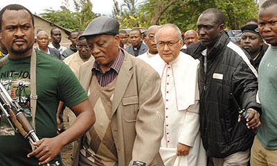 Plain clothed police officers escort Vatican envoy to Tanzania Archbishop Francisco Montecillo Padilla away from the scene after a grenade exploded at a church ceremony in Arusha on Sunday leaving one person dead and 60 injured. Net photo.