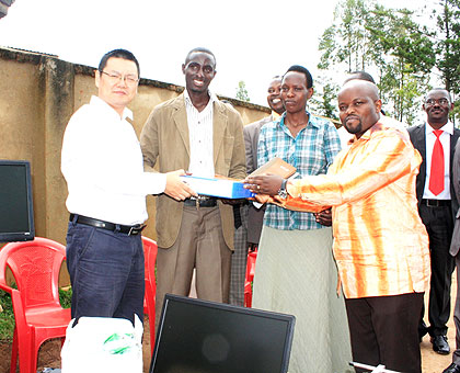 Youth and ICT minister Jean P. Nsengimana (R) and Justin Liu, the StarTimes Rwanad CEO, hand over donations to youth during the launch of the Youth Connekt in Kabaya sector yesterday. Cooperative Isamaza received two computers, a TV screen and a decoder. The minister urged the youth to embrace a savings culture and join cooperatives so as to strengthen their contribution in national development.  The New Times/ JP Bucyensenge.