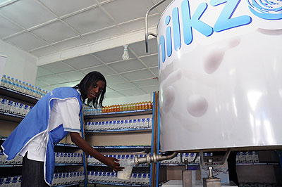 A shop attendant serves milk at a kiosk. The government has partnered with USAID to improve the mill value chain. The New Times / File photo 