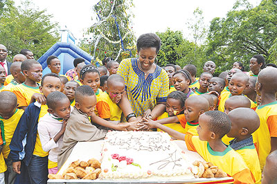 The First Lady cuts a cake with a group of children at a past Christmas Party. The New Times / Courtesy.