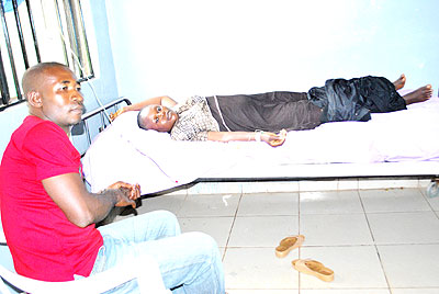 A man attends to his wife, who had pregnancy complications, in a hospital. Involving men in maternal health is crucial. Net photo.