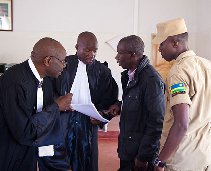 Bandora (2R) talks to his lawyers during court session yesterday.   The New Times/ Timothy Kisambira. 