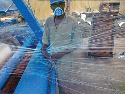 A Utexirwa worker arranges threads at the spinner. The New Times / Peterson Tumwebaze