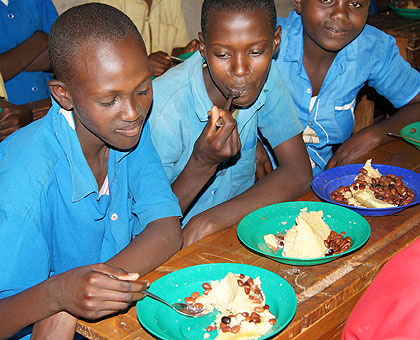 Pupils have their meal at school. The New Times/ Timothy Kisambira.