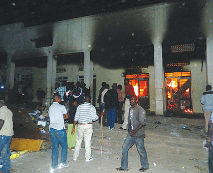 Residents trying to put out the fire that gutted a building in Muhanga on Friday. Sunday Times/ iPeterson Tumwebaze