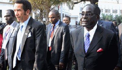 Botswana President Ian Khama (L) walks alongside Zimbabwe President Robert Mugabe (R) during a lunch break at the SADC summit in Maputo on June 15, 2013. Southern African leaders held a meeting to discuss Zimbabweu2019s political crisis after Prime Minister Morgan Tsvangirai vowed last week to oppose a decision by President Robert Mugabe to hold elections by July 31. Net photo.