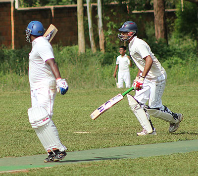 Shiva Samba (right) wants to make a quick second run but is stopped by his team mate, who sensed danger from the fielder.  The New Times / Courtesy.