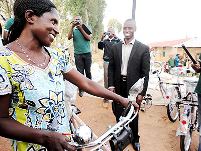 A beneficiary smiles after receiving a bicycle from Amir. The New Times/ Jean Pierre Bucyensenge.