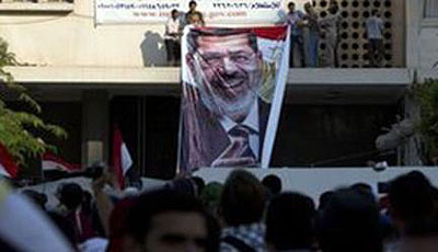 Mohammed Morsy supporters holding placards to demand his immediate reinstatement outside the Presidential Guard barracks where the Egyptian former leader is thought to be held. Net photo.