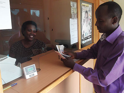 Uwimbabazi serving a customer at her Prime Forex Burea.  The New Times / File