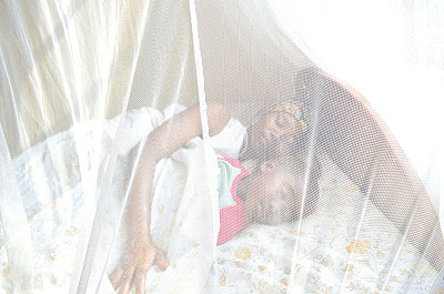 A mother and her baby sleep inside a treated mosquito net. Courtesy photo.