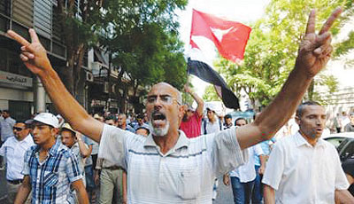 Tunisian supporters of the Islamist Ennahda party and others following Friday noon prayers in Habib Bourguiba avenue in the capital Tunis. Net photo.