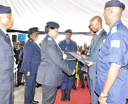 Senior Superitendent Teddy Ruyenzi (L) receives her certificate from Minister Harerimana. The New Times/ Jean Mbonyinshuti.