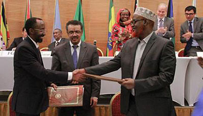 Somali Federal government representative, Farah Sheikh Abdulkadir (left), and Jubaland Administration representative, Sheikh Ahmed Mohammed Madobe (right), exchange signed copies o....