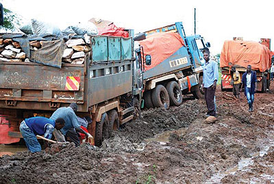 Trucks stuck on one of the countryu2019s rural districtsu2019 road after a heavy downpour recently. The Uganda government says oil money will be used on infrastructure like roads. Net photo