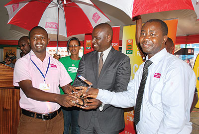 Musani (left) and another Movit worker receive the Best Innovative firm award from the PSF chairman Benjamin Gasamagera. The New Times / Courtesy photo