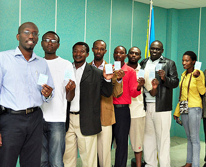 Rwandans in India proudly show off their voteru2019s cards as they queue to choose their parliamentary candidates yesterday.  The New Times/ Courtesy.