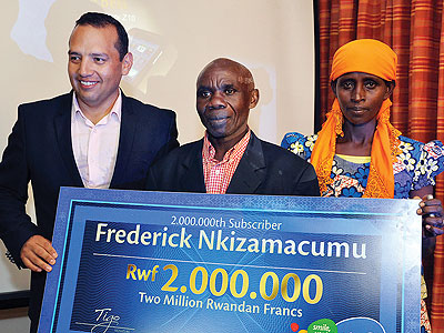 Nkizamacumu (middle) receives a Rwf2m dummy cheque flanked by his wife and Camberos. The New Times/Ben Gasore