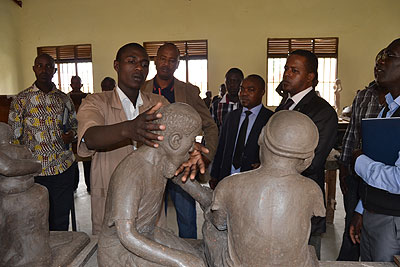 Thomas Mvugirende, one of the candidates showing State Minister and other WDA officials his sclupture. The New Times J Mbonyinshuti