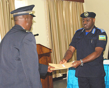 IGP Gasana (R)gives a certificate of merit to one of the participants.   Saturday Times/. Rwembeho.