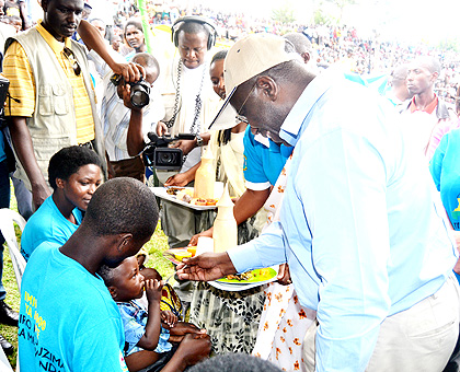 Habumuremyi feeds a child during the launch of the campaign to root out malnutrition on Saturday.  The New Times/ J. Mbonyinshuti.