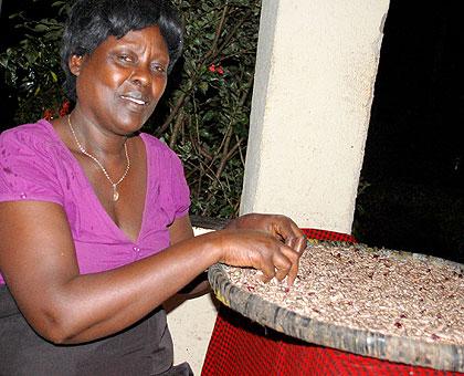 Gru00e2ce Mukagatare sorting beans at her home. Sunday Times/Jean-Pierre Bucyensenge