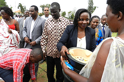 Minister Isumbingabo gives a resident a cooking stove during the World Energy Day celebrations in Rwamgana yesterday.  The New Times/ S. Rwembeho.