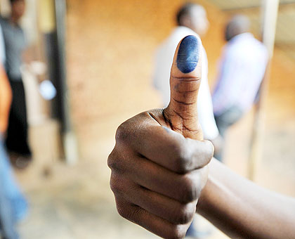 A voter does a thumbs-up sign to show ink marks after casting a vote. The New Times/T. Kisambira