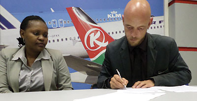 Norlem (right) signs the agreement as Kariuki looks on. The New Times / Ivan Ngoboka