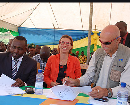 Delbaere (R) and mayor Mugisha sign an agreement on the project as Dr Katharina Jenny of the Swiss cooperation Agency looks on.    The New Times/ Jean Pierre Bucyensenge