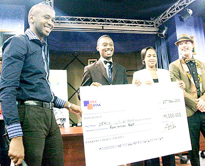 Herve Tuyishime (2ndL) receives a dummy cheque from Rosemary Mbabazi, the permanent secretary in the Ministry of Youth and ICt, as Fina Banku2019s Jean Claude Mutajogire (L) and Educt's Andreas Noerlem looks on.   The New Times/ John Mbanda.