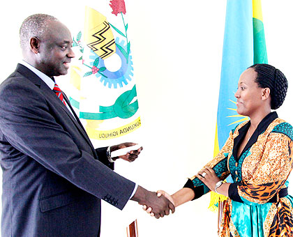 Minister Busingye congratulates Mukayiranga after she was sworn in as a bailiff to serve the Access to Justice Bureau yesterday. The New Times/ John Mbanda.