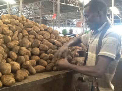 A trader sorts out Irish potatoes for sale. The New Times/Su00e9raphine Habimana