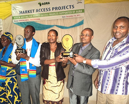 Farmers, AGRA officials and local leaders display trophies won in Acra-Ghana. The New Times/ S. Rwembeho.