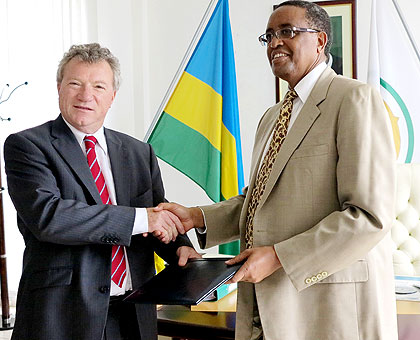 Prof. Lwakabamba (R) and Ryan exchange paperwork after the signing yesterday. The New Times/John Mbanda