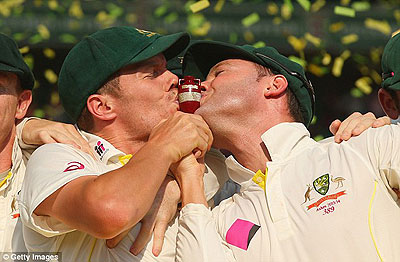 Peter Siddle and Michael Clarke kiss the urn at the awards ceremony. Net photo.