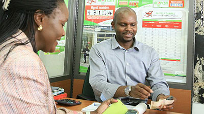 A Safaricom M-Pesa dealer serves a customer. The telecom firm controls over 80 per cent of the Kenya market.  Net photo