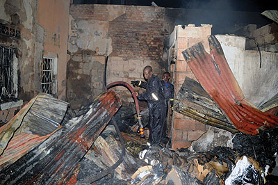 Firemen unhooking a water hose after extinguishing a fire that razed city businesses last year. The New Times /File 