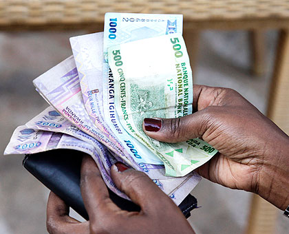 A woman counts Rwandan francs. EAC is envisioned to have a single currency.  The New Times/ File.