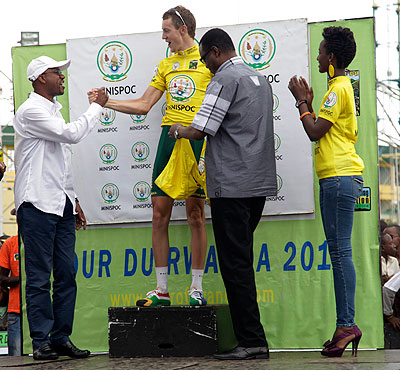 Ferwacy chairman, Aimable Bayingana (L) congratulates South Africau2019s Dylan Girdlestone after he had won the 2013 Tour of Rwanda as Sports Minister Protais Mitali looks on. Saturday Sport/John Mbanda.