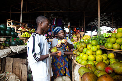 A woman sells friuts in Kicukiro market. Experts have called for more support to the private sector.  The New Times/ T. Kisambira.