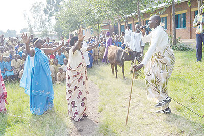 Some of the teachers who received cows for their excellent performance. Right is a man in traditional cloth singing a song  traditionally dedicated to cows. The New Times/T. Kisambira 