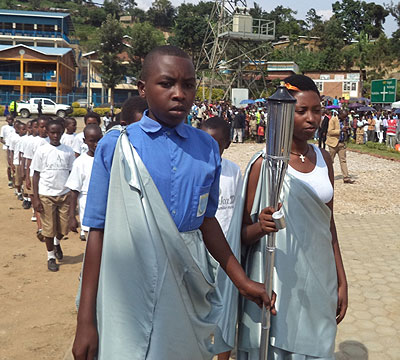 Innocent Rukundo and Annualite Kayitesi carry the Kwibuka Flame at its arrival in Bwishyura, Karongi District on Thursday. The New Times/ Bucyensenge