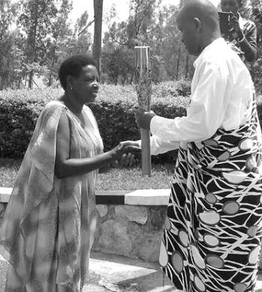 Judith Nyinawumwami, a farmer in Nyanza, hands over the Queenu2019s Baton to the Director for Research and Publications Jerome Karangwa. Times Sport / S. Kwihangana.